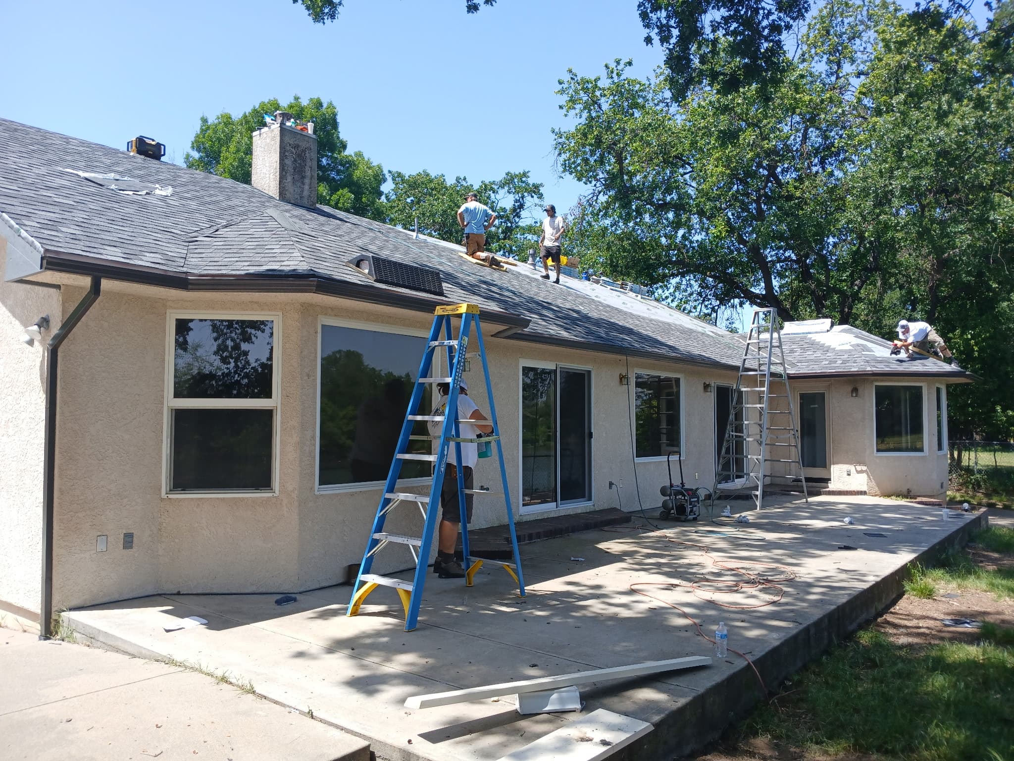 Crew on the roof installing seamless gutters on a single-story home in Anderson
