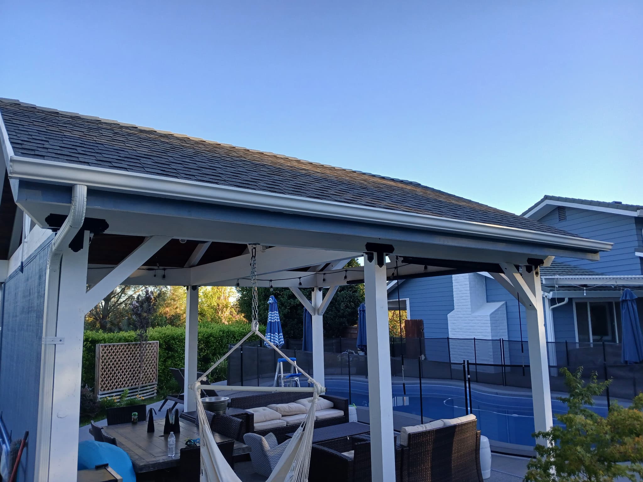 Outdoor patio with new white seamless gutters along the soffit line in Redding