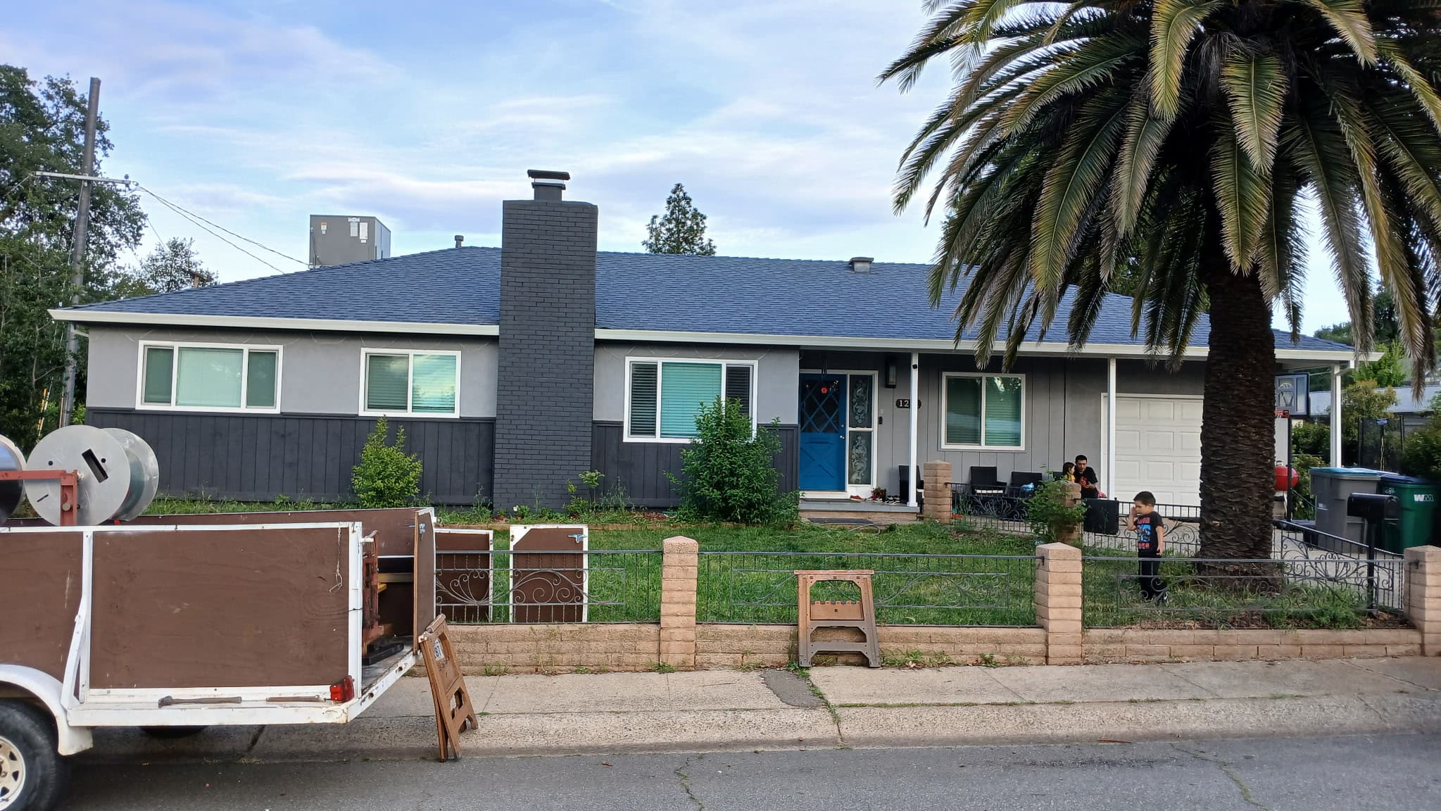 Fresh white seamless gutters on a gray ranch home with palm tree in Redding